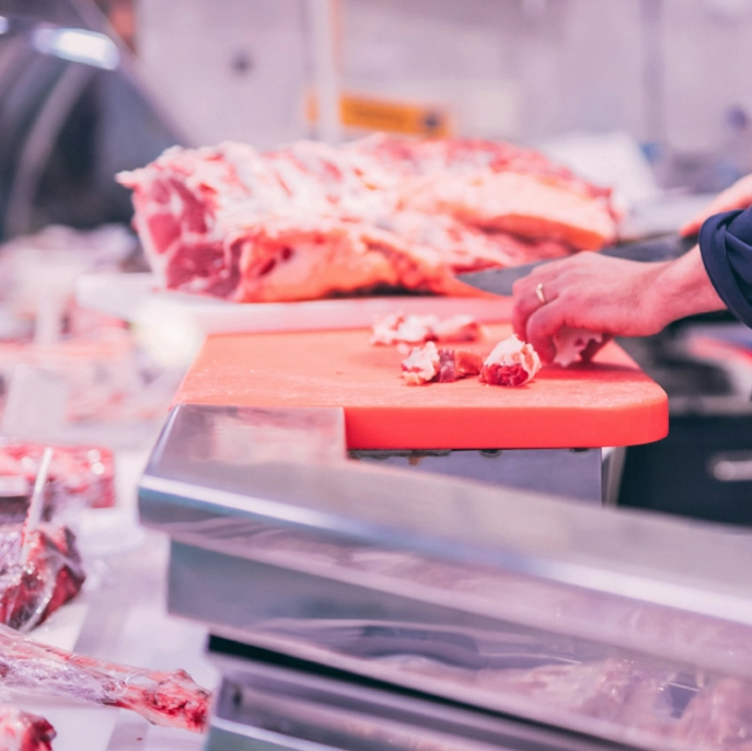 Découpe de viande fraîche par un boucher à Massieux