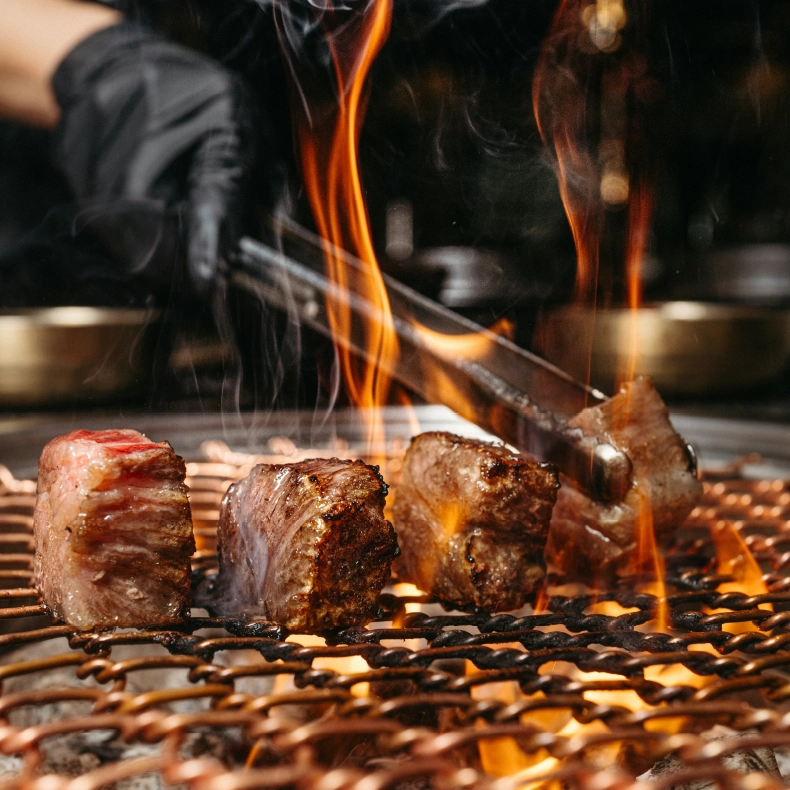 Viande grillée au barbecue argentin avec flammes vives à Massieux